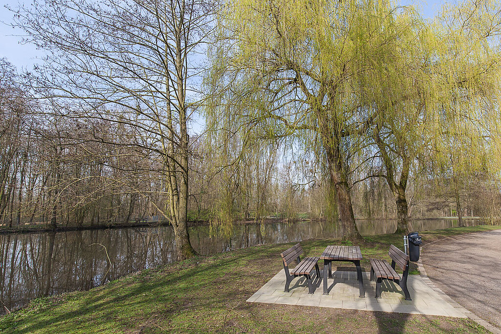 Der Bresgespark im Frühjahr. Die Sitzgruppen am Weiher unter den Trauerweiden laden zum Verweilen ein.