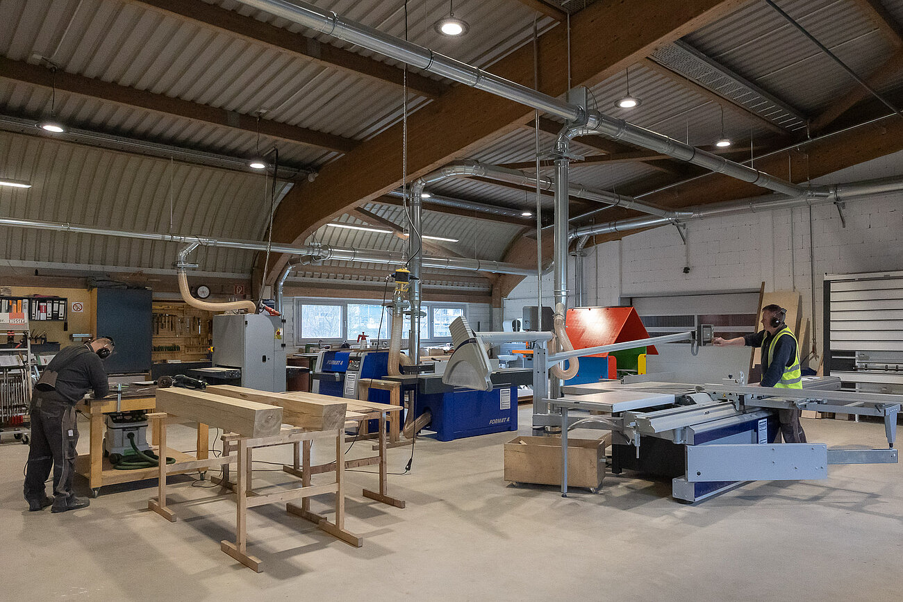 Das Foto zeigt die moderne Werkstatt der mags-Spielplatzunterhaltung. In dem Fall die Schreinerei mit vielen Maschinen, um Holz zu schneiden